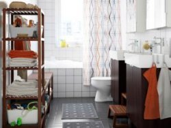A bathroom with white wall tiles, grey flooring tiles as well as 2 black-brown washbasin cabinets. Along with two wall cabinets with mirror doors and darkish shelving units.