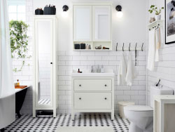 A white restroom with tiles, wash-stand and large closet with mirror home. Combined with a white wash-basin and a wall cabinet with mirror doorways.